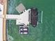 An aerial view of a private boat dock equipped with boat lift and jet skis on clear blue water at 2233 Donato Dr, Belleair Beach, FL 33786