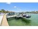 Dockside view with jet skis parked on the boat lift on a sunny day at 2233 Donato Dr, Belleair Beach, FL 33786
