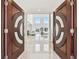 Grand entryway featuring custom double doors and a view into a spacious living area with water views at 2233 Donato Dr, Belleair Beach, FL 33786