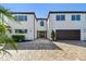 Two-story home boasts modern architecture, a decorative door, an attached garage and tasteful landscaping at 2233 Donato Dr, Belleair Beach, FL 33786