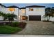 Elegant two-story home boasting well-manicured landscaping, a paved driveway, and a two-car garage at 2233 Donato Dr, Belleair Beach, FL 33786