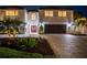 Stunning two-story home with a brick driveway, manicured landscaping, and a two-car garage at 2233 Donato Dr, Belleair Beach, FL 33786