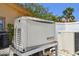 A home standby generator and air conditioner unit on a stone pad with a white privacy fence at 2233 Donato Dr, Belleair Beach, FL 33786