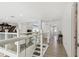 Bright hallway with a piano and elegant furniture. Features glass railings and light-colored flooring at 2233 Donato Dr, Belleair Beach, FL 33786