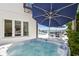 Inviting hot tub near the water, complemented by comfortable patio seating and shade umbrellas at 2233 Donato Dr, Belleair Beach, FL 33786