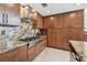 Modern kitchen with granite countertops, stainless steel appliances, and ample wooden cabinetry at 2233 Donato Dr, Belleair Beach, FL 33786