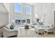 Bright, spacious living room with large windows and sliders offering views of the pool and waterfront at 2233 Donato Dr, Belleair Beach, FL 33786
