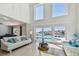 Bright living room with tile floor, high ceilings, large windows overlooking the pool and waterfront at 2233 Donato Dr, Belleair Beach, FL 33786