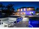 Rear of house at night with water access, dock, pool, and outdoor seating at 2233 Donato Dr, Belleair Beach, FL 33786