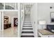 Bright foyer with a staircase featuring dark wood treads and white risers, leading to the upper level at 2233 Donato Dr, Belleair Beach, FL 33786
