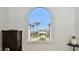 Window view showcases the neighboring home, lush palm trees, and a clear blue sky at 2233 Donato Dr, Belleair Beach, FL 33786