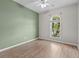Cozy bedroom with neutral walls, wood flooring, and a large arched window at 23935 Coral Ridge Ln, Land O Lakes, FL 34639