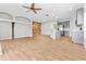 Open living room with wood tile flooring, wood accent wall, and gray kitchen cabinets at 23935 Coral Ridge Ln, Land O Lakes, FL 34639