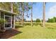 Backyard view from screened lanai overlooking green lawn, tall trees, and distant golf course at 23935 Coral Ridge Ln, Land O Lakes, FL 34639