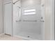 All-white tiled walk-in shower with grab bars, shower head, and window for natural light at 23935 Coral Ridge Ln, Land O Lakes, FL 34639