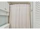 A bathroom with a neutral shower curtain, toilet, built-in shelving and a shuttered closet at 2400 Feather Sound Dr # 735, Clearwater, FL 33762