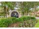 Community sign: Audubon Condominiums, featuring lush landscaping with flowers and tropical palm trees at 2400 Feather Sound Dr # 735, Clearwater, FL 33762