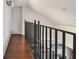 Upstairs hallway with wood floors and wrought iron railings, overlooking the living room at 2400 Feather Sound Dr # 735, Clearwater, FL 33762
