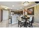 Modern kitchen with stainless steel appliances, granite countertops, and a cozy dining area with decorative lighting at 2400 Feather Sound Dr # 735, Clearwater, FL 33762
