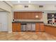 Community kitchen area with wood cabinets, sink, and stainless steel appliances at 2400 Feather Sound Dr # 735, Clearwater, FL 33762