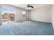 Bright bedroom featuring a large window, a sliding glass door, and soft blue carpeting at 2700 Bayshore Blvd # 511, Dunedin, FL 34698