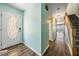 Inviting entryway with wood-look floors, staircase, and partial water view at end of hallway at 2700 Bayshore Blvd # 511, Dunedin, FL 34698