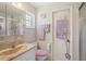 Bathroom featuring wallpaper, framed mirror and vanity with peach sink and toilet with fuzzy purple cover at 2702 Ochatilla Rd, Holiday, FL 34691