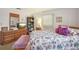 Cozy bedroom with purple accent pillows, wooden furnishings, and a TV at 2702 Ochatilla Rd, Holiday, FL 34691