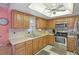 Functional kitchen features wooden cabinets, stainless steel appliances, and a unique ceiling fan at 2702 Ochatilla Rd, Holiday, FL 34691