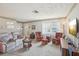 Cozy living room featuring a comfortable sofa, rocking chairs, and natural light from large windows at 2702 Ochatilla Rd, Holiday, FL 34691