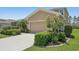 Exterior shot of a beige two-story home featuring a well-kept lawn, mature landscaping and an attached two car garage at 2803 130Th E Ave, Parrish, FL 34219