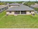 Back exterior of home with large screened in patio, a spacious yard, and central air conditioning units at 2803 130Th E Ave, Parrish, FL 34219