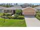 Charming home featuring lush landscaping, a paved driveway, and an attached two-car garage at 2803 130Th E Ave, Parrish, FL 34219