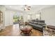 Sunlit living room featuring a gray leather sofa, patterned armchairs, and sliding glass doors to a covered lanai at 2803 130Th E Ave, Parrish, FL 34219