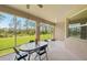 A screened patio with an oval table and seating offers serene views of the lush green backyard at 2803 130Th E Ave, Parrish, FL 34219