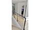 Hallway with modern cable railing, light wood floors, and doorways to different rooms, enhancing a minimalist design at 2904 N Ola Ave, Tampa, FL 33602