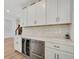 Kitchen featuring white cabinets, stainless steel appliances, stone countertops, and wood floors at 2904 N Ola Ave, Tampa, FL 33602