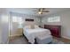 Cozy bedroom features wood-look floors, a ceiling fan, and a comfortable bed with a tufted ottoman at 3075 Rosery Ne Rd, Largo, FL 33771