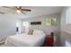 Spacious bedroom with a ceiling fan, a cozy bed with decorative pillows and ample natural light at 3075 Rosery Ne Rd, Largo, FL 33771