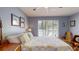 Bedroom with a wooden frame bed, light blue walls and large windows at 3075 Rosery Ne Rd, Largo, FL 33771