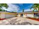 Inviting single-story home with an attached two-car garage, a well-kept lawn, and decorative features at 3075 Rosery Ne Rd, Largo, FL 33771