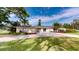 Inviting single-story home featuring a well-manicured lawn, ample parking, and lush landscaping at 3075 Rosery Ne Rd, Largo, FL 33771