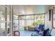 Enclosed porch with blue outdoor seating, tile floors, and views of the backyard at 3075 Rosery Ne Rd, Largo, FL 33771