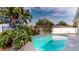 Backyard pool surrounded by tropical plants and a privacy fence, with a concrete pool deck at 3075 Rosery Ne Rd, Largo, FL 33771