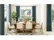 Sunlit dining room with contemporary table, chairs, modern buffet and statement drapery for an inviting space at 31793 Griffin Sands Ln, San Antonio, FL 33576