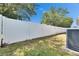 Long and pristine white fence bordering the backyard, with an AC unit nearby at 32628 Harmony Oaks Dr, Wesley Chapel, FL 33545