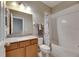 Full bathroom with granite counters, wooden cabinets, a shower with tub and marble shower curtain at 32628 Harmony Oaks Dr, Wesley Chapel, FL 33545
