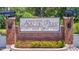 Community welcome sign with brick base and attractive landscaping at 32628 Harmony Oaks Dr, Wesley Chapel, FL 33545