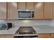 Close-up of stainless steel microwave and glass top stove with granite countertops at 32628 Harmony Oaks Dr, Wesley Chapel, FL 33545
