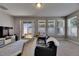 Cozy living room with natural light, black couch, and access to backyard at 32628 Harmony Oaks Dr, Wesley Chapel, FL 33545